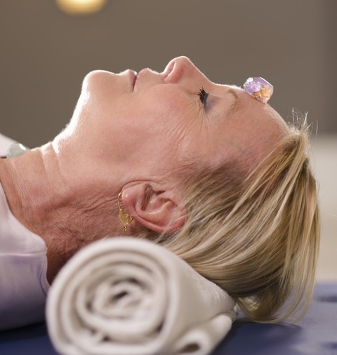Senior woman relaxing and doing therapy with crystals